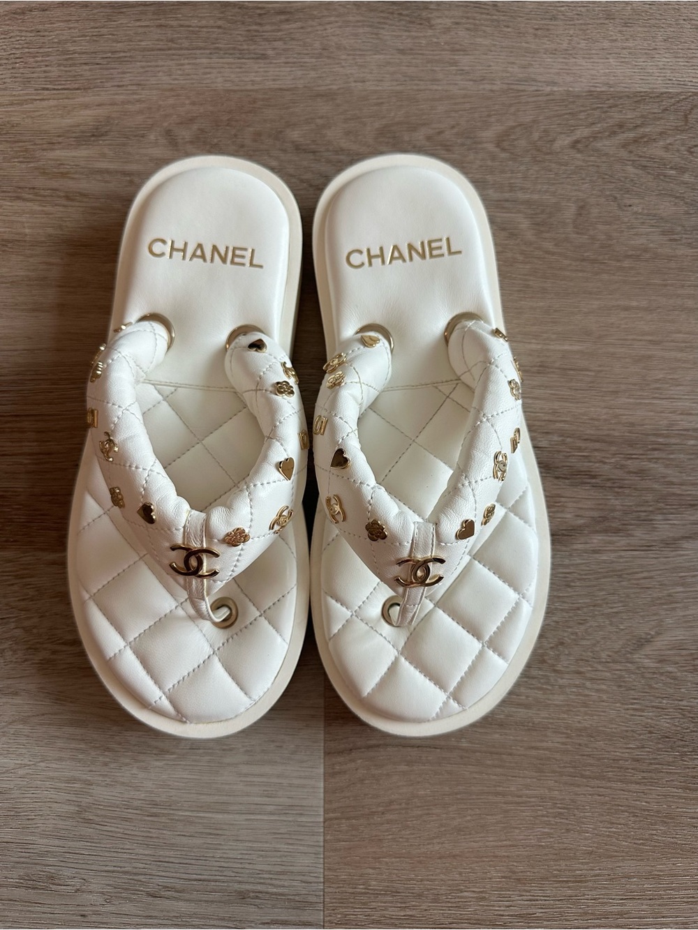 CHANEL 23S White Quilted Logo Flip Flops with Gold Charms